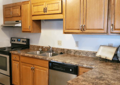 A contemporary kitchen with essential appliances: a sink, stove, and refrigerator, designed for efficiency and comfort.